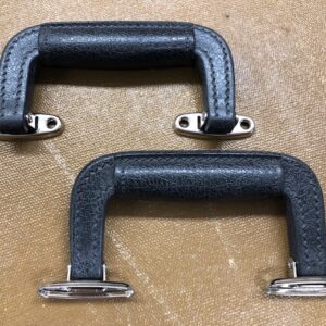 Molded suitcase handle with attached mounting brackets